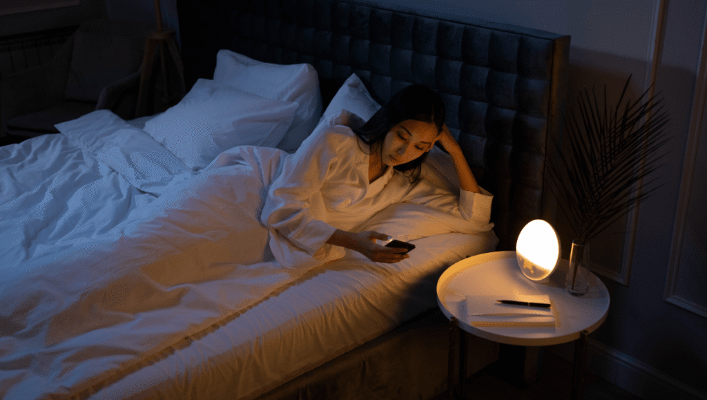 el descanso que no descansa - mujer viendo una pantalla en la cama por la noche