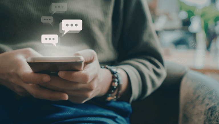Manos sosteniendo un celular como representación del consumo digital y la sobreestimulación
